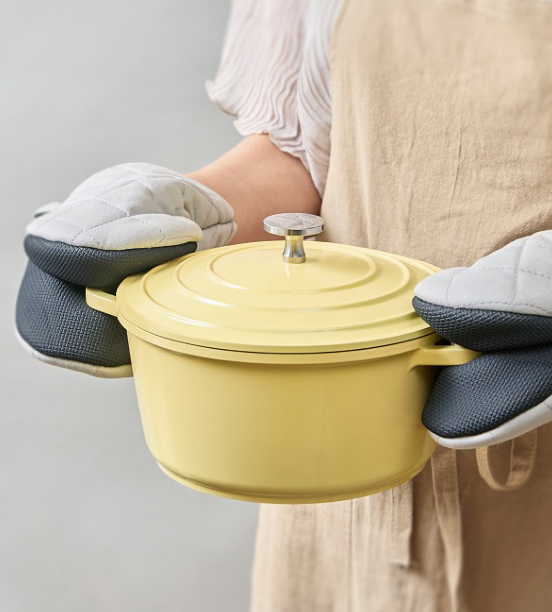 蓋付き鍋を両手で持っている画像